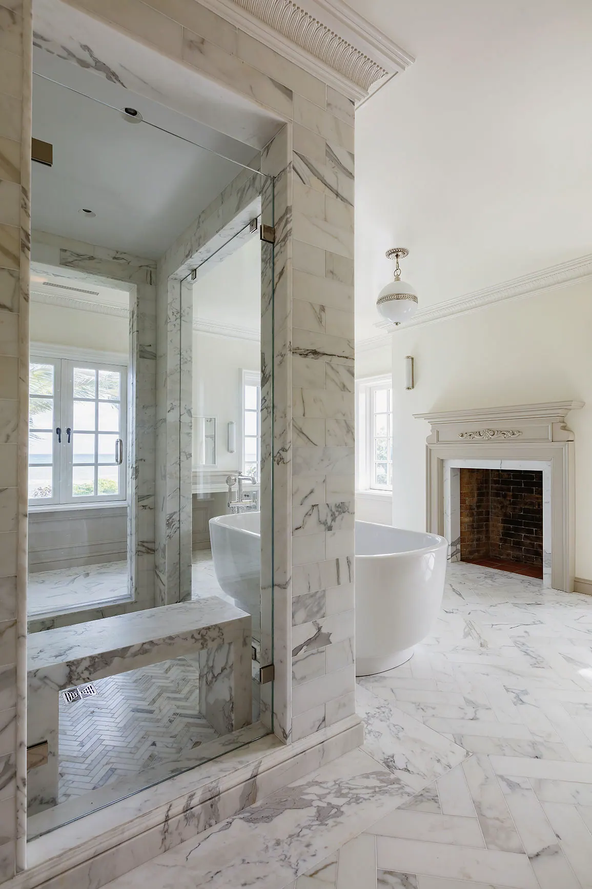 Marble shower looking out to a freestanding tub