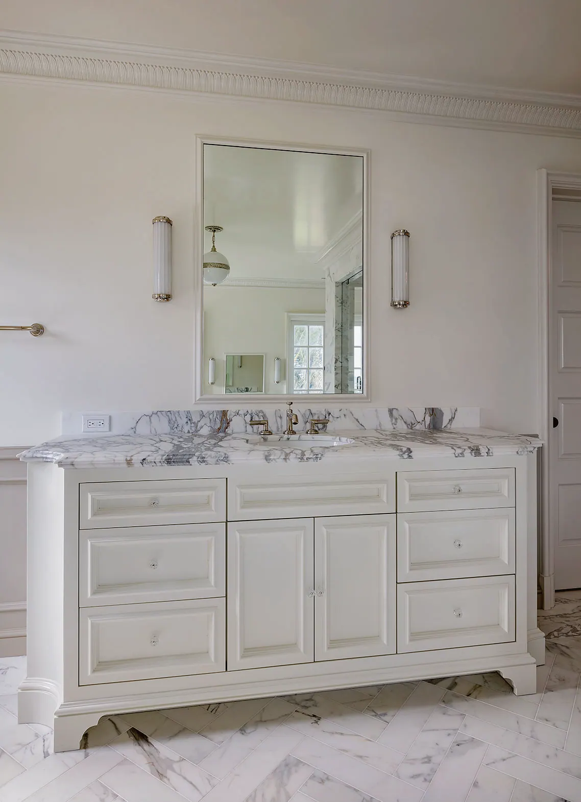 White double vanity with a marble top and a framed mirror