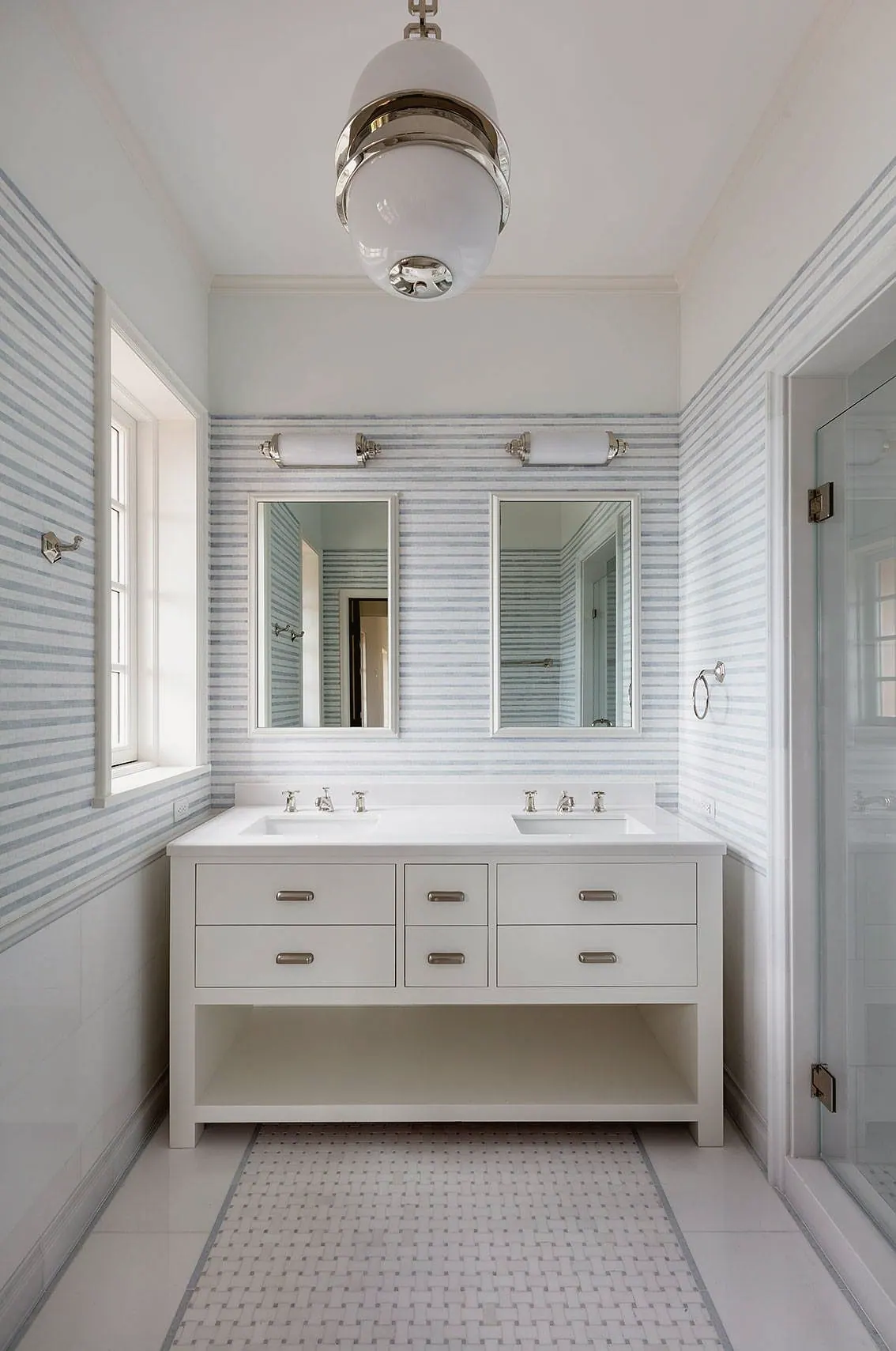 White bath with a double vanity and a pendant light