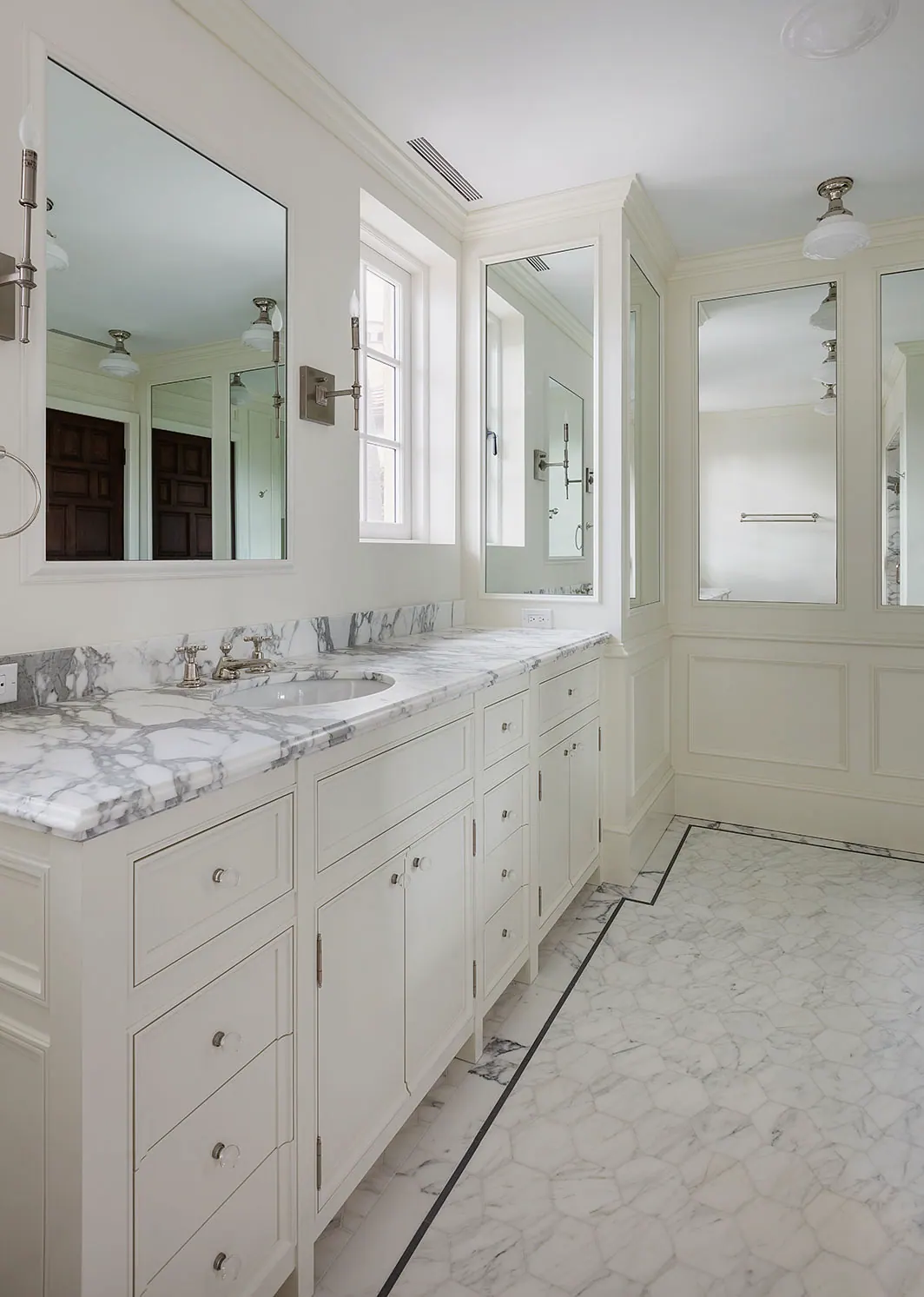 Long double vanity in a white marble bath