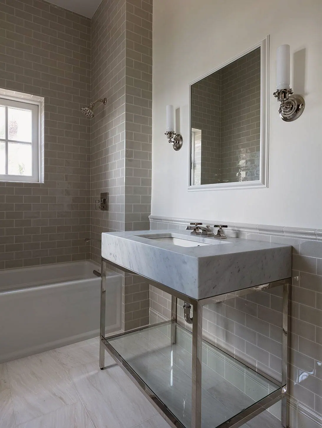Console sink on a nickel stand against gray tile
