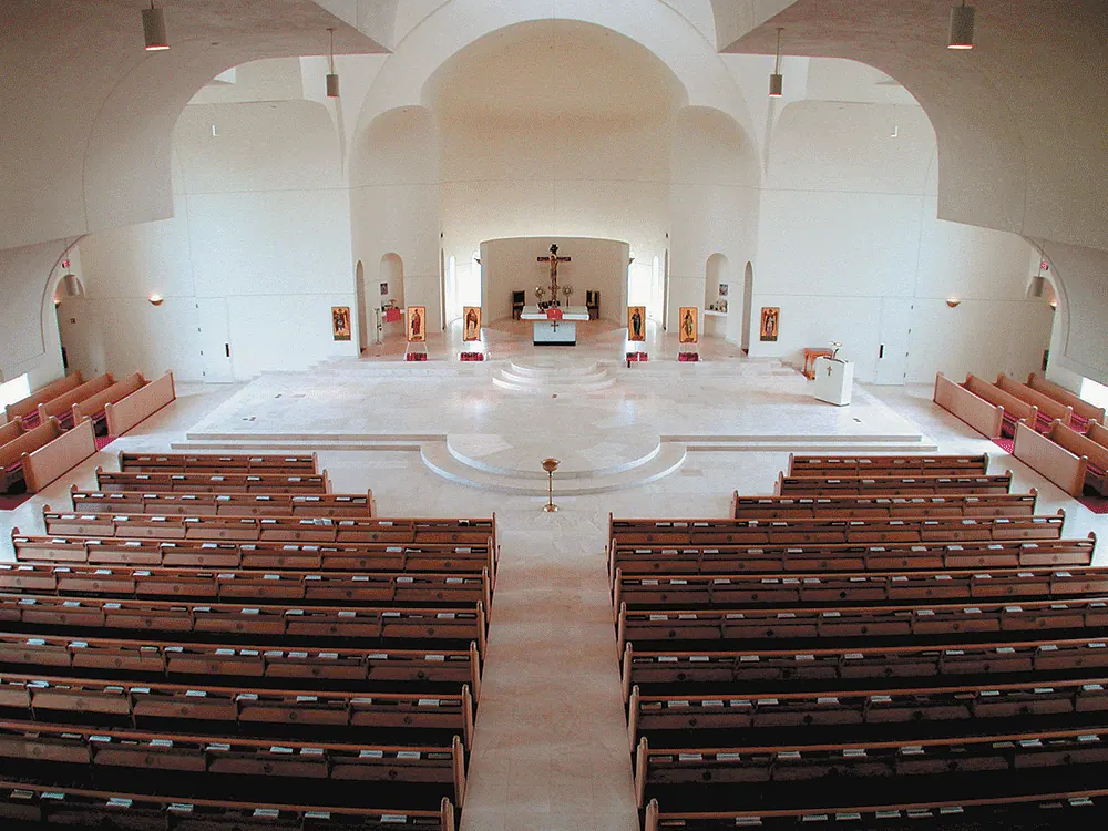 Nave with wood pews under a domed ceiling