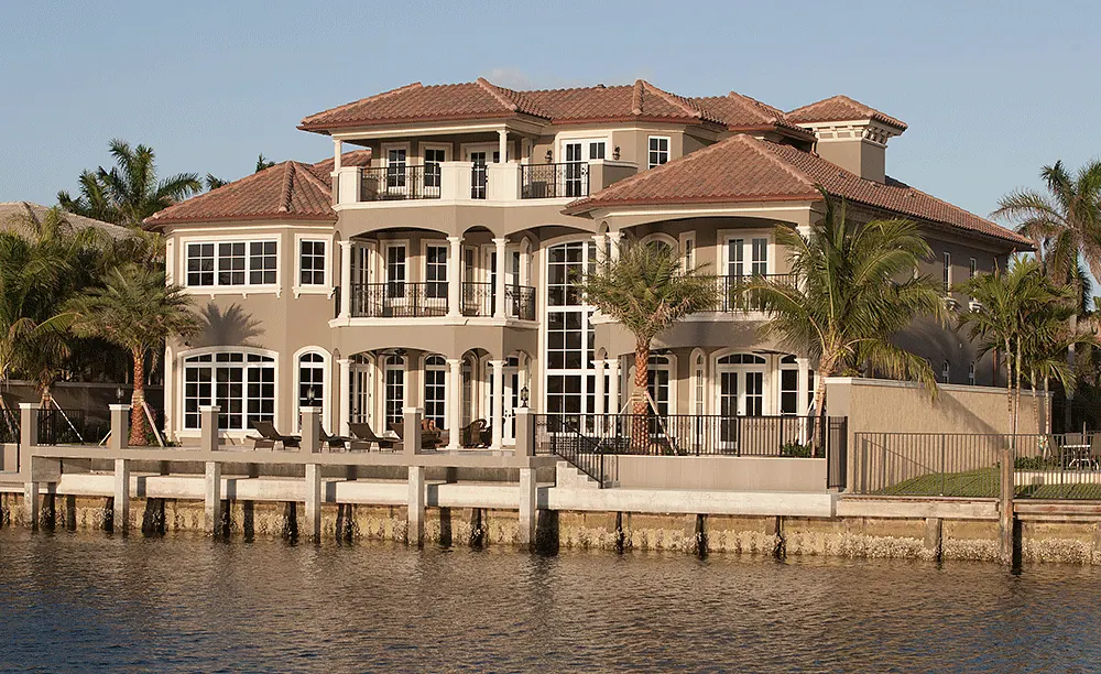 Three-story Mediterranean house on the water, with a seawall and dock