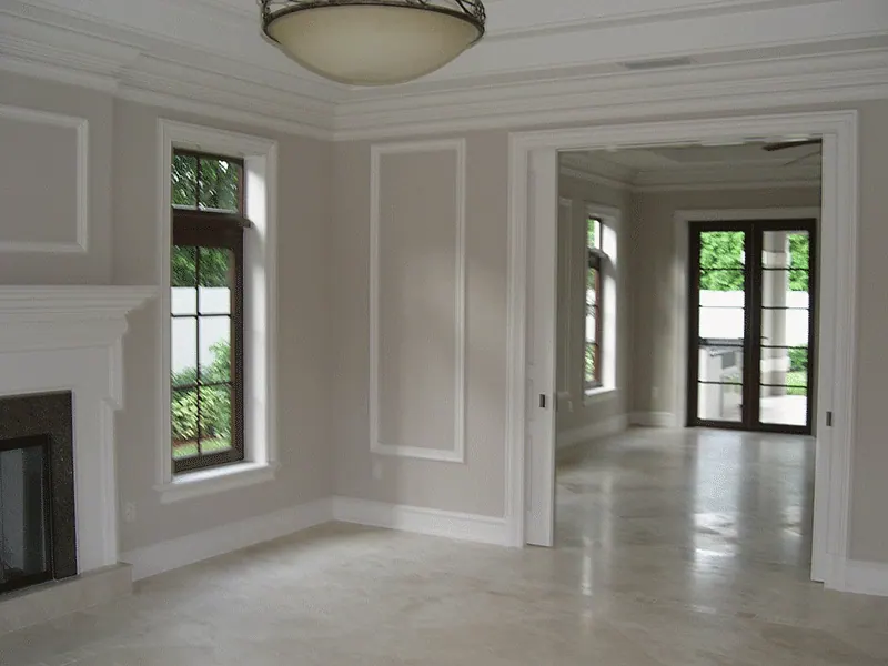 Living room with a fireplace, raised panel walls and French doors