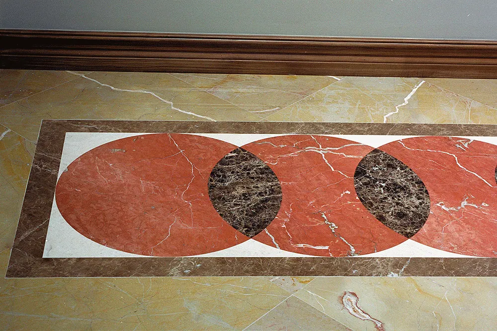 Marble floor inlay of red and dark ovals in a stone border