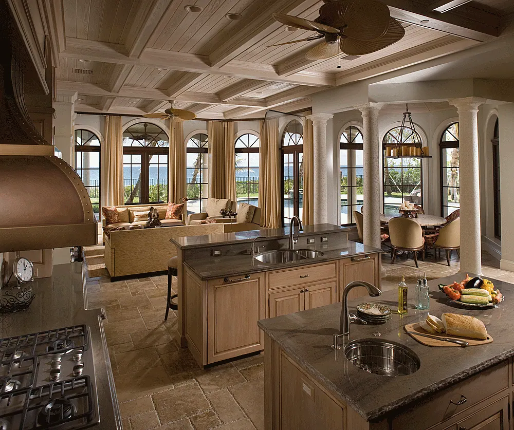 Kitchen open to a family room with arched windows and a coffered ceiling