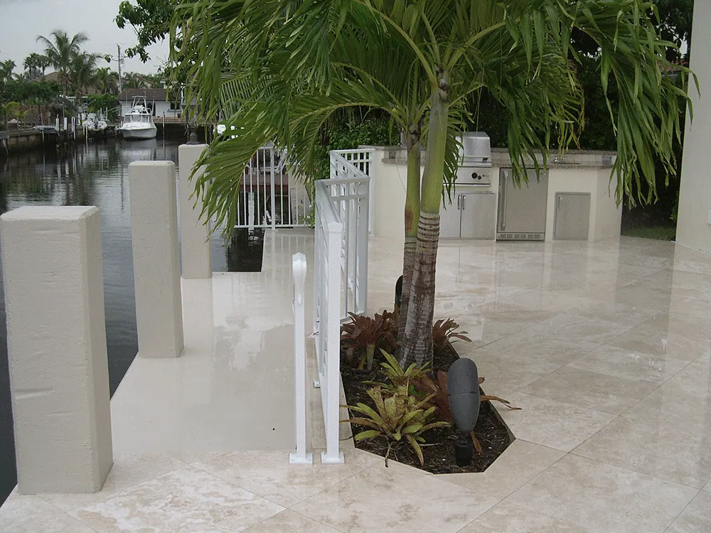 Outdoor kitchen on a travertine deck beside a dock
