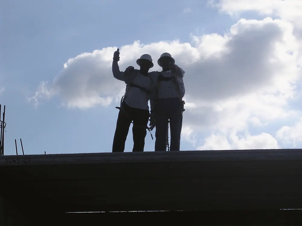 Two people on a roof deck looking out over the site