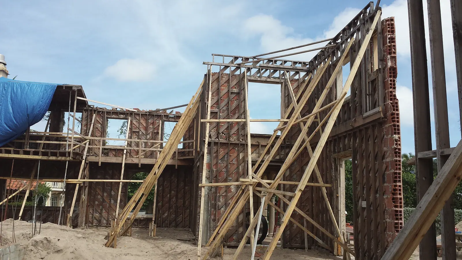 Existing wood and clay block walls braced with diagonal timber shoring during a renovation